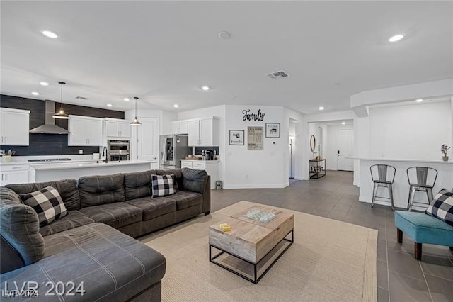 living room with tile patterned floors and sink