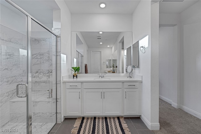 bathroom featuring vanity, a shower with shower door, and tile patterned flooring