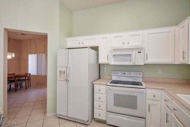 kitchen featuring white cabinets, white appliances, and light tile patterned floors