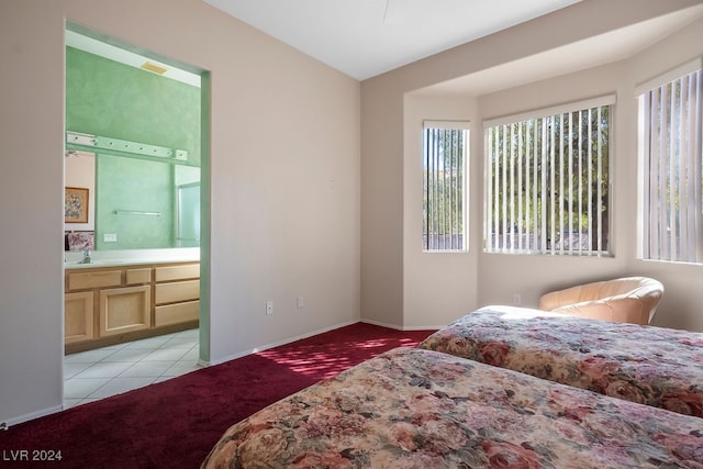 carpeted bedroom featuring sink and connected bathroom