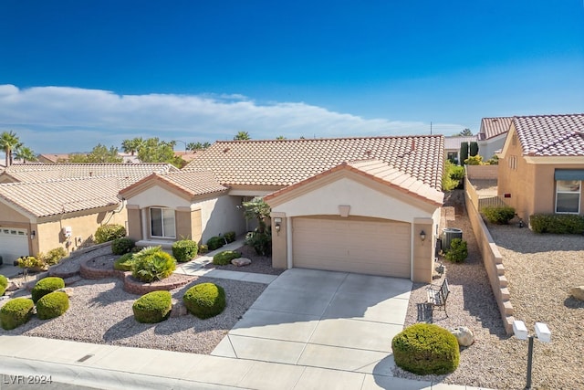 mediterranean / spanish-style home with central AC unit and a garage