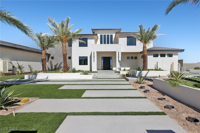 view of front of property with a balcony and a front lawn