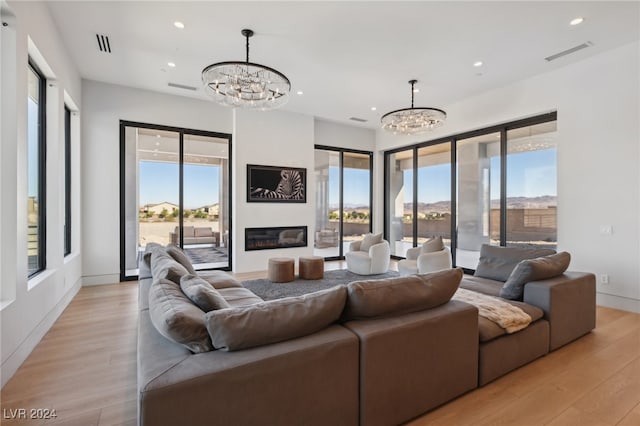 living room with light wood-type flooring and a notable chandelier