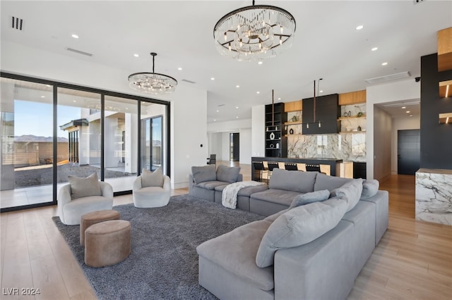 living room featuring light wood-type flooring and a notable chandelier