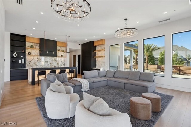 living room with a notable chandelier and light hardwood / wood-style flooring