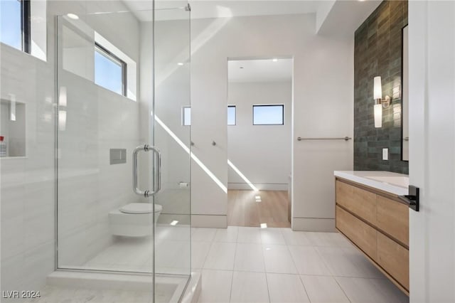 bathroom with tile patterned flooring, vanity, toilet, and a shower with shower door