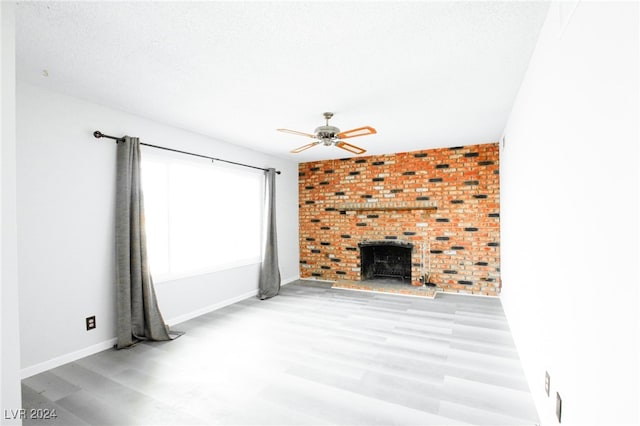 unfurnished living room with a textured ceiling, light hardwood / wood-style floors, and ceiling fan