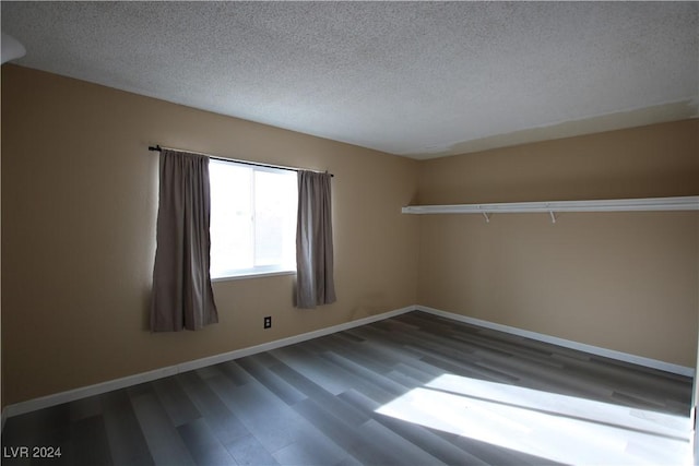 spare room featuring wood-type flooring and a textured ceiling