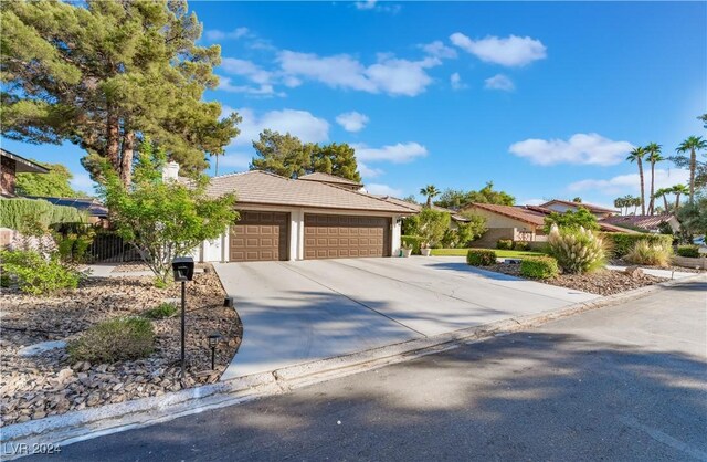 2504 Windjammer Way, Las Vegas, NV 89107 - view of front of home featuring a tiled roof, an attached garage, driveway, and stucco siding