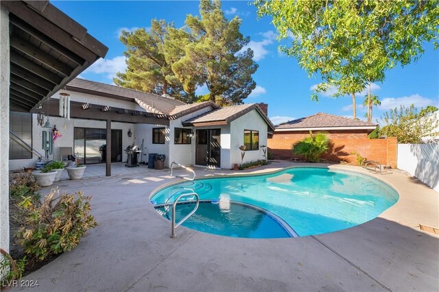 2504 Windjammer Way, Las Vegas, NV 89107 - view of swimming pool featuring a patio, a fenced backyard, and a pool with connected hot tub