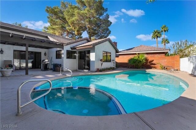 2504 Windjammer Way, Las Vegas, NV 89107 - view of pool with a pool with connected hot tub, a patio, and a fenced backyard