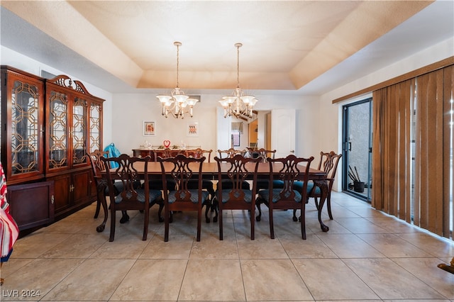 dining space featuring light tile patterned floors, an inviting chandelier, and a raised ceiling