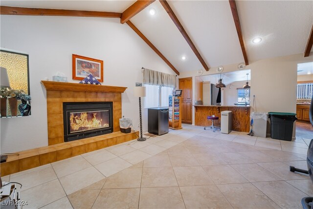 living room with light tile patterned flooring, beamed ceiling, high vaulted ceiling, and a fireplace