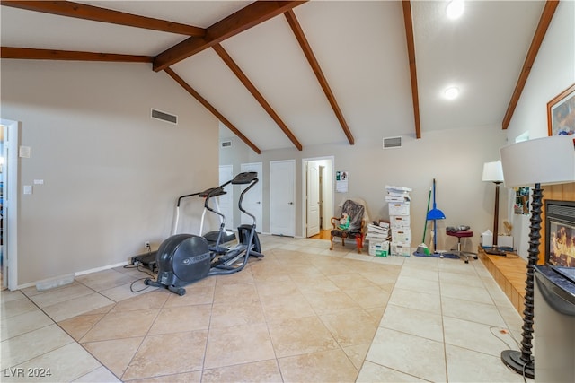 exercise room featuring high vaulted ceiling and light tile patterned floors