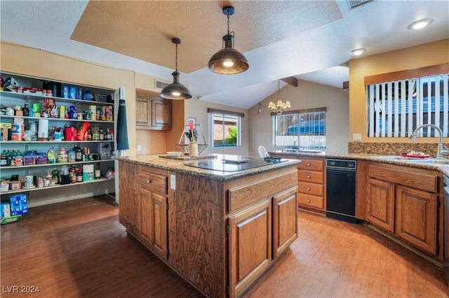 kitchen with lofted ceiling, a kitchen island, light hardwood / wood-style flooring, hanging light fixtures, and sink