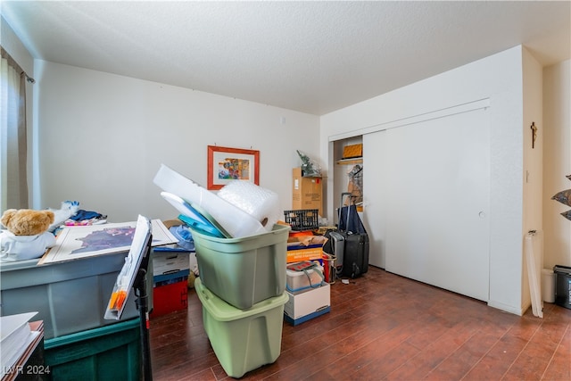 bedroom featuring a closet, a textured ceiling, and dark hardwood / wood-style floors