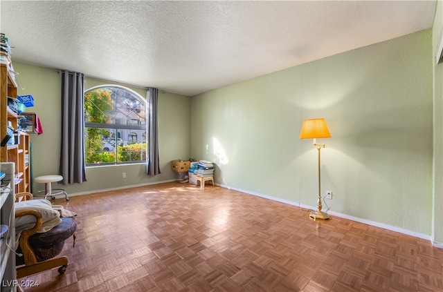 unfurnished room with parquet floors and a textured ceiling