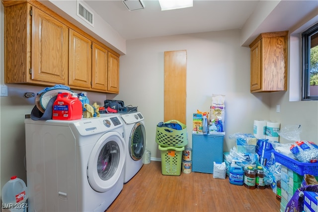 laundry room featuring light hardwood / wood-style flooring, cabinets, and independent washer and dryer