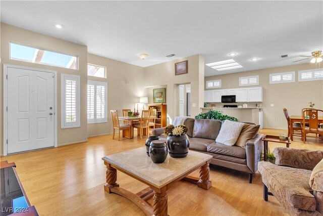 living room with ceiling fan and light hardwood / wood-style flooring