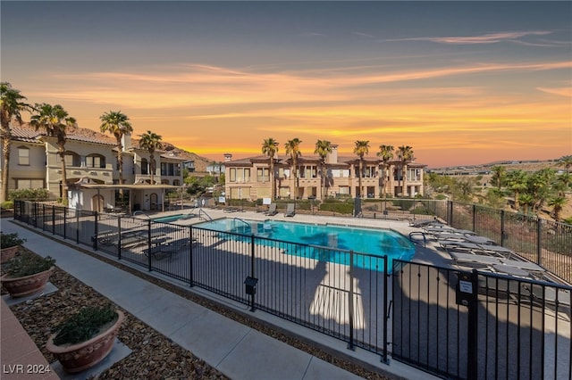 pool at dusk featuring a patio area