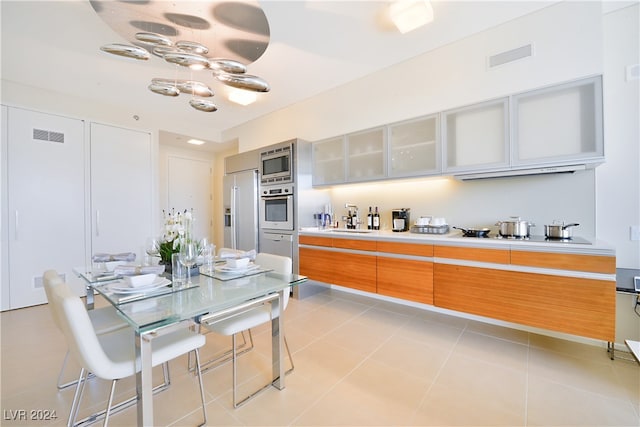 kitchen with sink, light tile patterned flooring, and stainless steel appliances