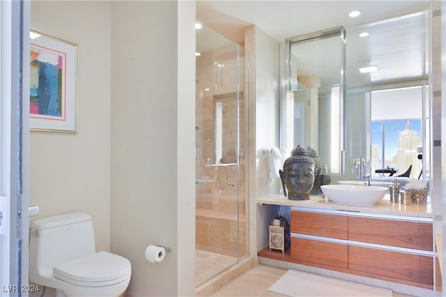 bathroom featuring toilet, vanity, tile patterned floors, and a shower with shower door