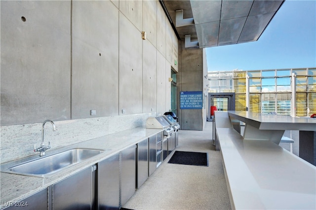 view of patio featuring grilling area, sink, and a balcony