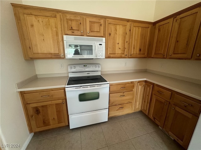 kitchen with light tile patterned flooring and white appliances