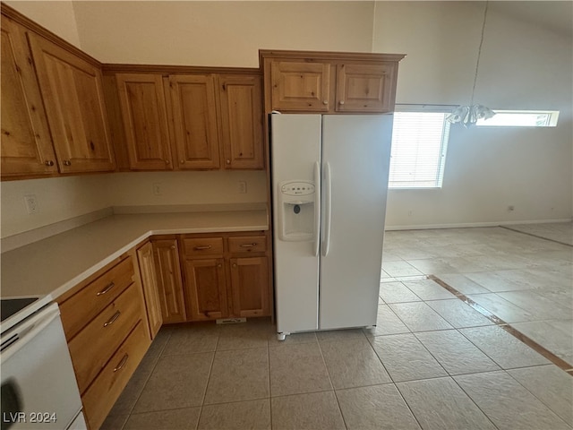 kitchen featuring a notable chandelier, light tile patterned floors, and white appliances