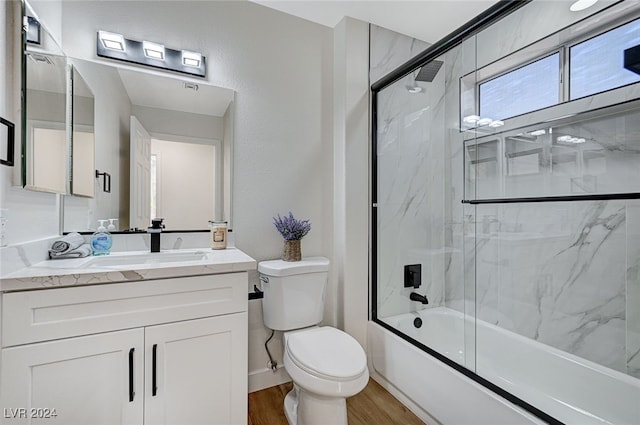full bath featuring enclosed tub / shower combo, toilet, vanity, and wood finished floors