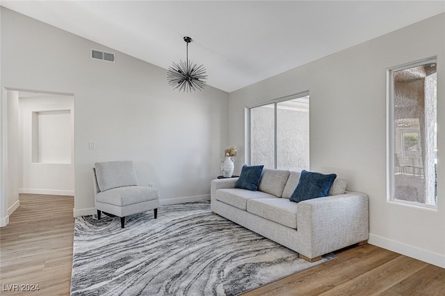 living area featuring light wood-style flooring, visible vents, and baseboards