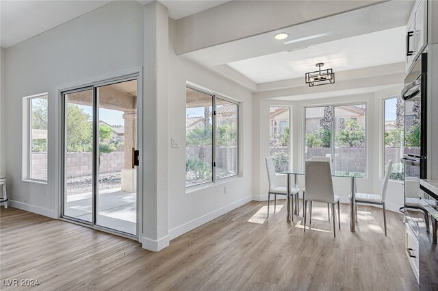 sunroom / solarium featuring a chandelier