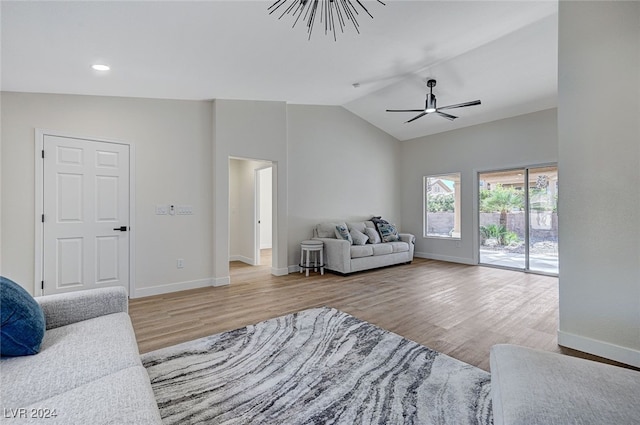 living area featuring a ceiling fan, baseboards, lofted ceiling, and wood finished floors