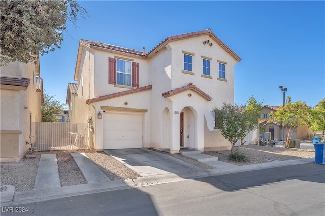 mediterranean / spanish-style home featuring a garage, a tile roof, concrete driveway, and stucco siding