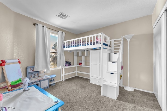 carpeted bedroom featuring a textured ceiling and a closet