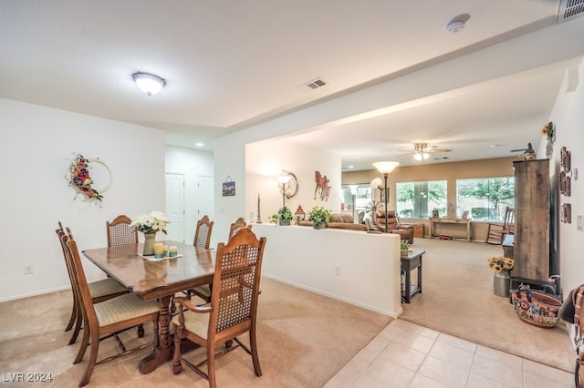 carpeted dining space with ceiling fan