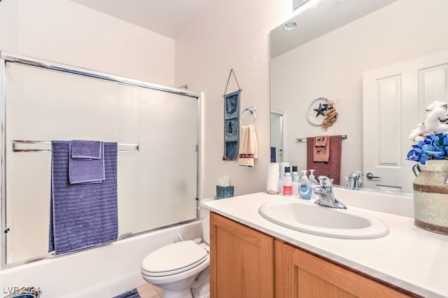 full bathroom with vanity, combined bath / shower with glass door, toilet, and tile patterned floors