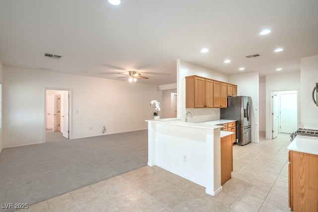 7625 Fieldfare Dr, North Las Vegas, NV 89084 - kitchen featuring stainless steel fridge, light colored carpet, ceiling fan, open floor plan, and light countertops