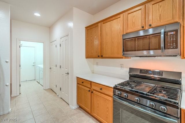 7625 Fieldfare Dr, North Las Vegas, NV 89084 - kitchen featuring stainless steel appliances, light countertops, washing machine and clothes dryer, light tile patterned floors, and recessed lighting