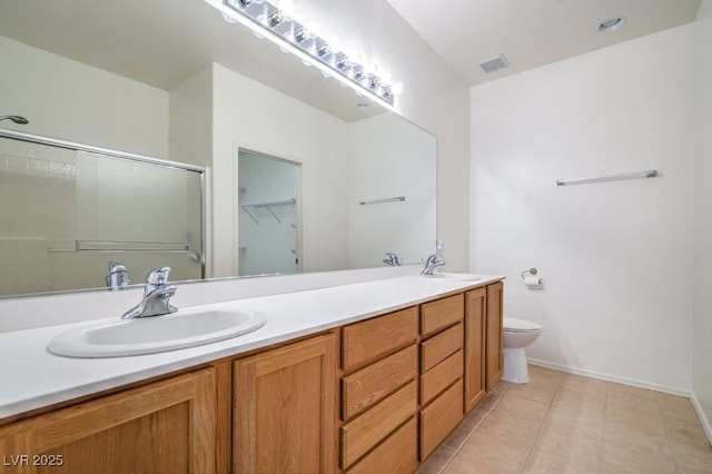 7625 Fieldfare Dr, North Las Vegas, NV 89084 - bathroom with double vanity, toilet, a shower with shower door, a walk in closet, and tile patterned floors