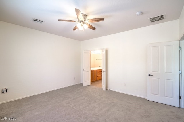 7625 Fieldfare Dr, North Las Vegas, NV 89084 - unfurnished bedroom with light carpet, baseboards, connected bathroom, and a ceiling fan