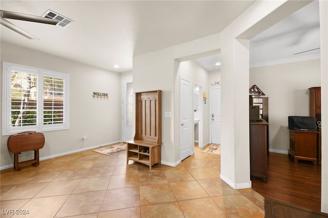 tiled foyer entrance with crown molding