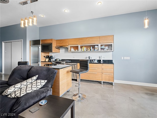 kitchen featuring light brown cabinets, hanging light fixtures, and built in appliances