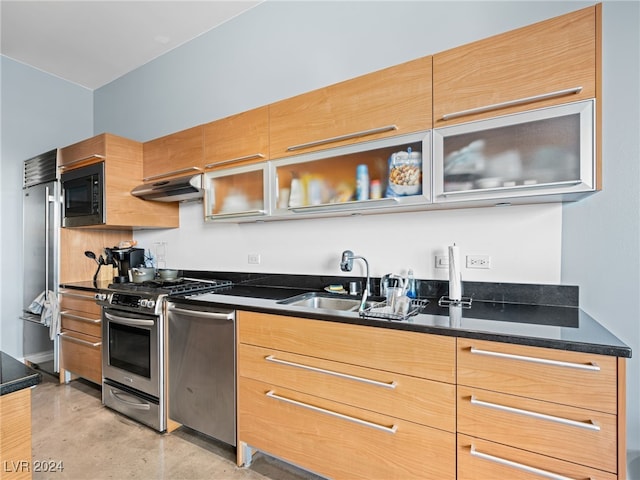 kitchen featuring extractor fan, sink, built in appliances, and dark stone counters