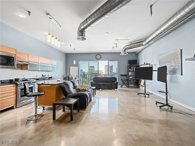 kitchen with appliances with stainless steel finishes, extractor fan, track lighting, and pendant lighting