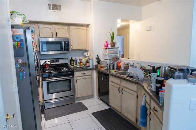 kitchen with light brown cabinets, stainless steel appliances, sink, and light tile patterned floors