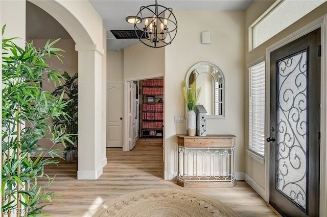 entrance foyer with an inviting chandelier and light hardwood / wood-style floors