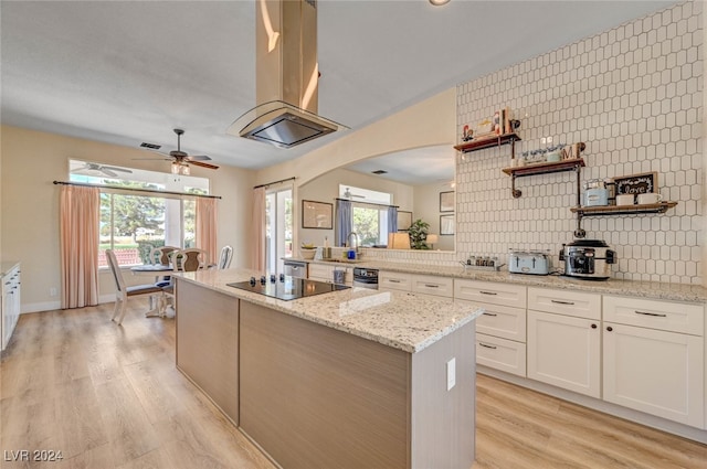 kitchen with black electric stovetop, light stone countertops, white cabinetry, and light hardwood / wood-style floors