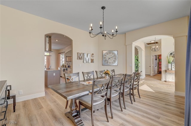 dining room with light hardwood / wood-style flooring, sink, and a notable chandelier