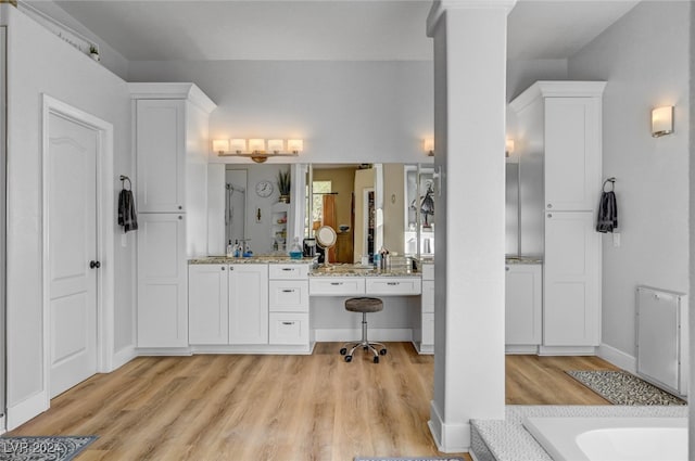 bathroom featuring vanity, a tub to relax in, and hardwood / wood-style floors